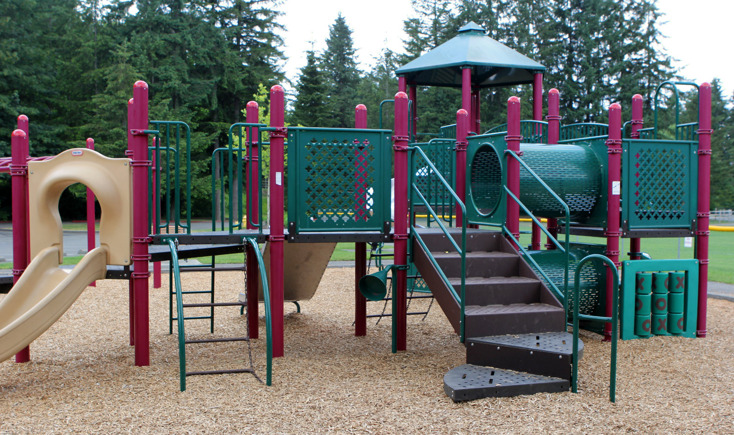 Outdoor playground unit at Beaver Lake Park containing slides, steps, crawling tunnels, and a tic-tac-toe game board.