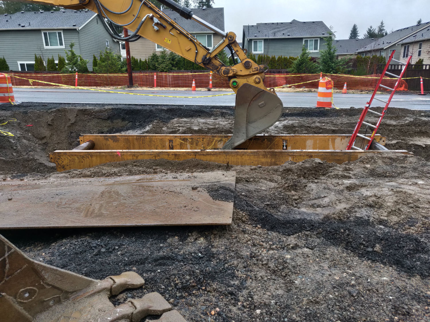excavator digging a trench beside existing road surface at Issaquah Fall City Road