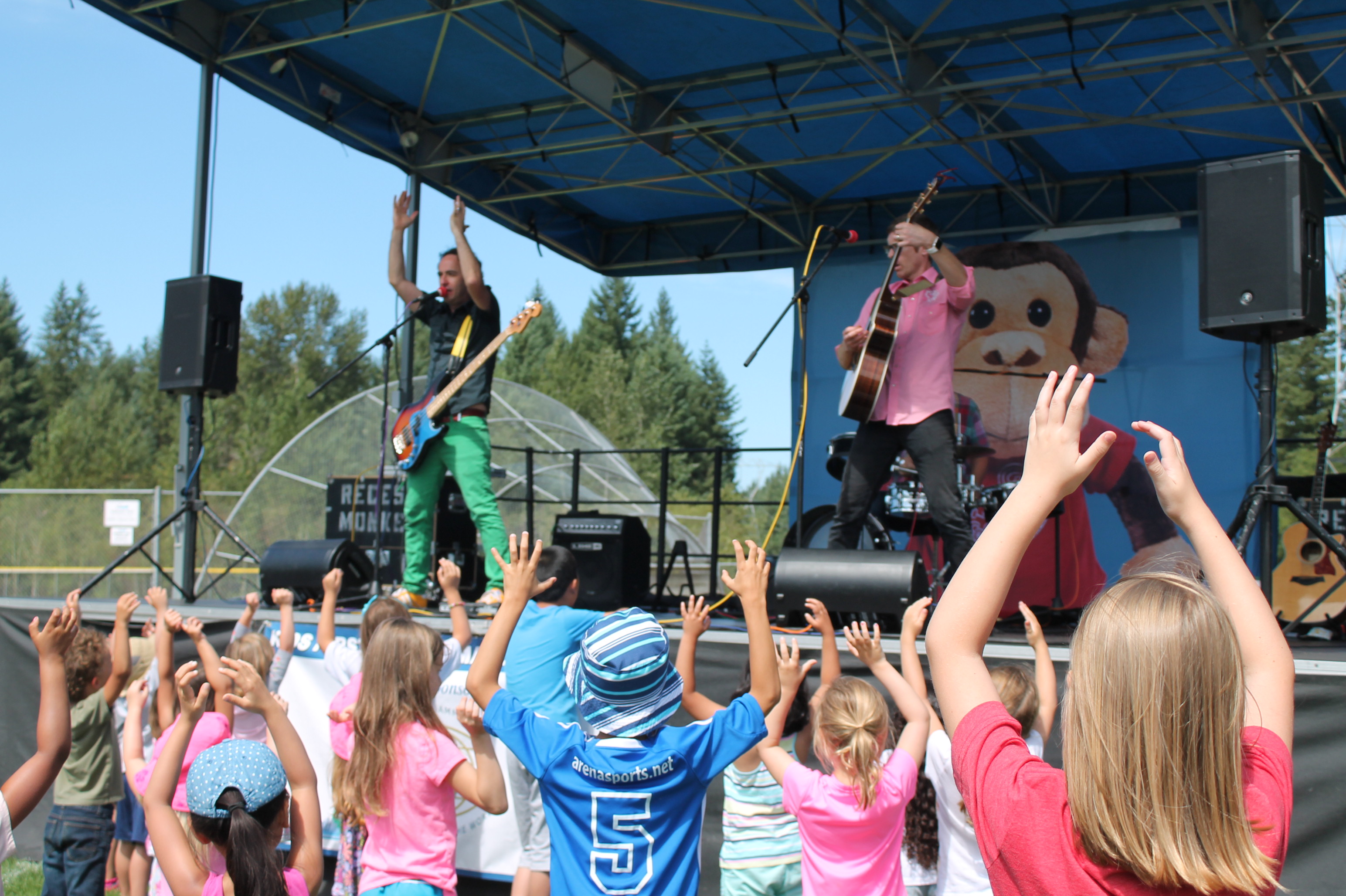 Children clapping and waving their hands in the air at a KidsFirst concert