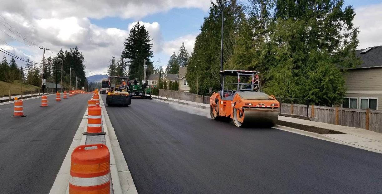 two rollers on fresh paving along four lanes of traffic with a median island and sidewalk on Issaquah Fall City Road