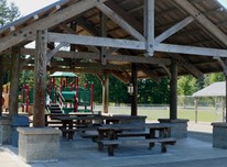 Beaver Lake Picnic Shelter with children's playground and sports fields in the background.
